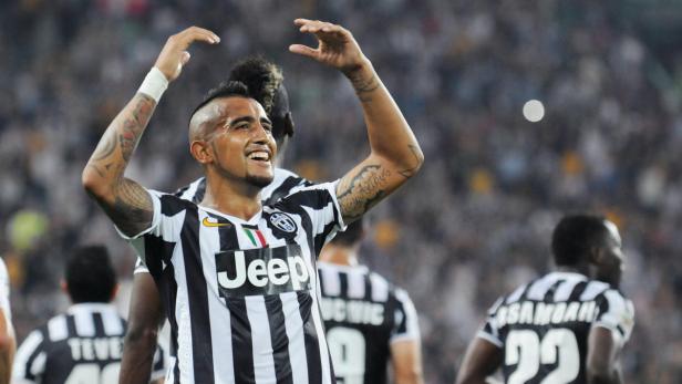 Arturo Vidal feiert in einem Trikot von Juventus Turin mit erhobenen Armen.