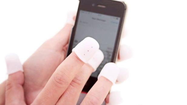 Eine Hand tippt mit Fingerlingen auf einem Smartphone.