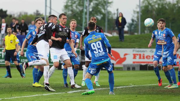 FAC - Linz Fußballspieler während eines Spiels in blauen und schwarzen Trikots.