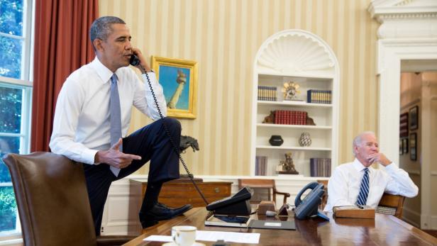 epa03845893 A photo made available by the White House press office shows US President Barack Obama, his right foot resting on the edge of his desk, in a telephone conversation in the Oval office with the Speaker of the House John Boehner late 31 August 2013. On right listening is US vice president Joe Biden. Obama has formally asked the US Congress to authorise military action against Syria over alleged chemical weapons attacks. EPA/PETE SOUZA HANDOUT EDITORIAL USE ONLY/NO SALES