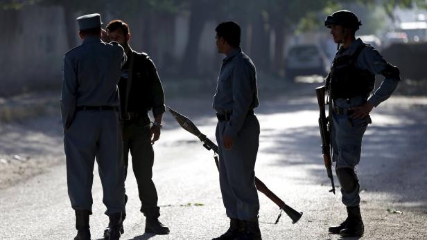 Bewaffnete Sicherheitskräfte stehen auf einer Straße.