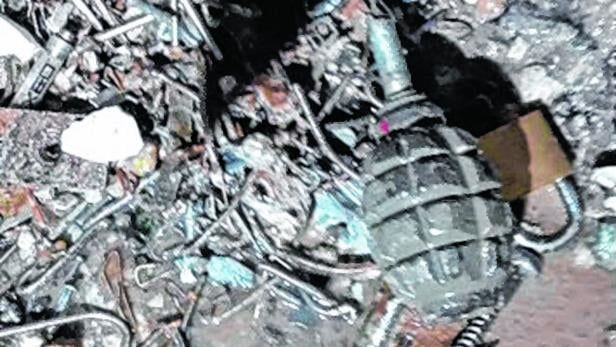 Eine Handgranate liegt inmitten von Trümmern.