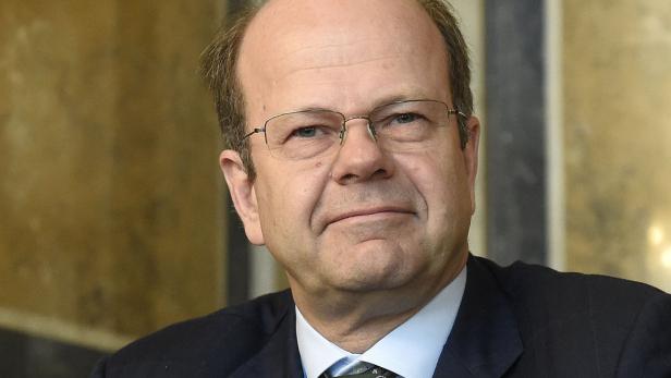 Ein Porträt eines Mannes mit Brille und Anzug.