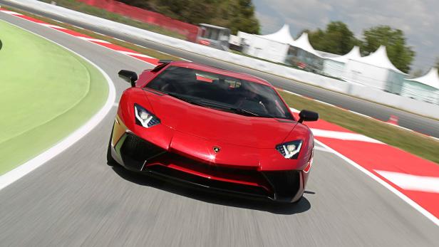 Ein roter Lamborghini fährt auf einer Rennstrecke.