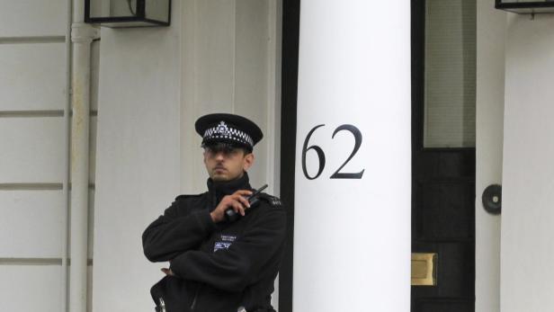 Ein Polizist steht vor der Hausnummer 62 Wache.