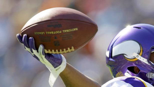 Ein Footballspieler der Vikings fängt einen Football.