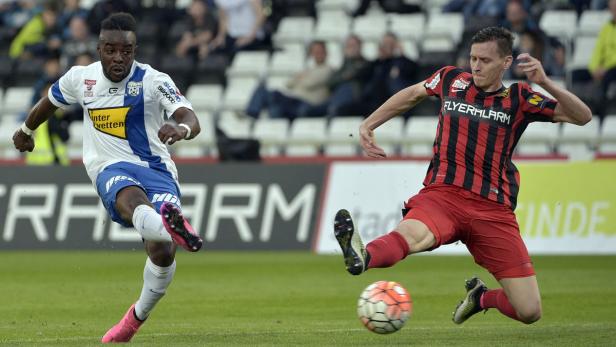 Zwei Fußballspieler kämpfen um den Ball während eines Fußballspiels.