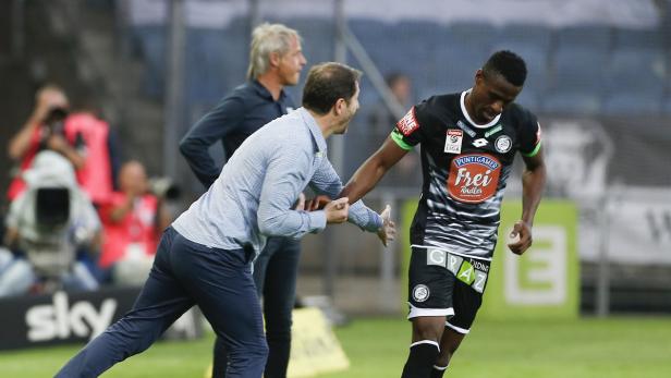 Ein Fußballspieler wird von einem Trainer ausgewechselt.