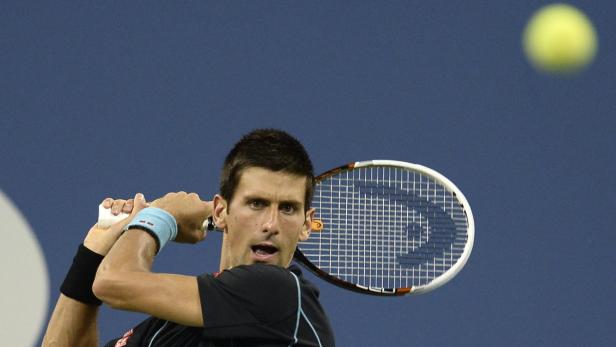 Novak Đoković schlägt einen Tennisball.