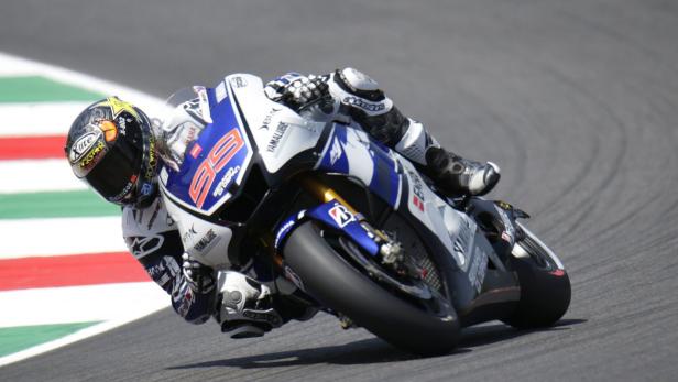 Ein Motorradfahrer in voller Montur fährt eine Yamaha-Maschine auf einer Rennstrecke.