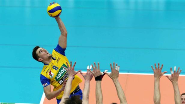 Ein Volleyballspieler schlägt den Ball über das Netz.