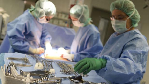 Ein Operationsteam führt einen Eingriff durch, Instrumente liegen bereit.