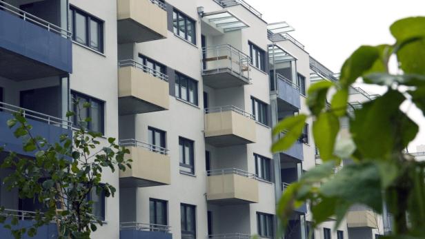Ein Mehrfamilienhaus mit blauen und beigen Balkonen im modernen Stil.