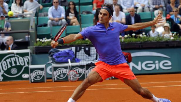 Roger Federer bei einem Tennismatch auf einem Sandplatz.