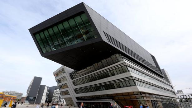 Die Bibliothek und das Lernzentrum der Wirtschaftsuniversität Wien mit Passanten im Vordergrund.