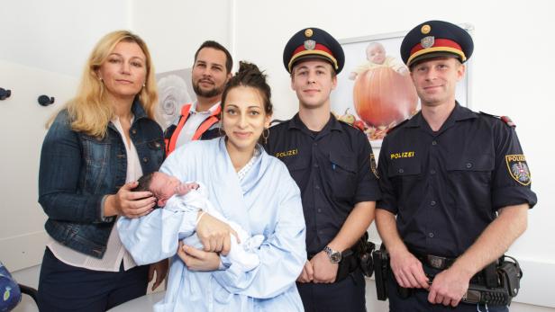 Die Mutter mit dem Neugeborenen, dazu die Geburtshelfer: links die Ärztin und der Sanitäter, rechts die beiden Polizisten.