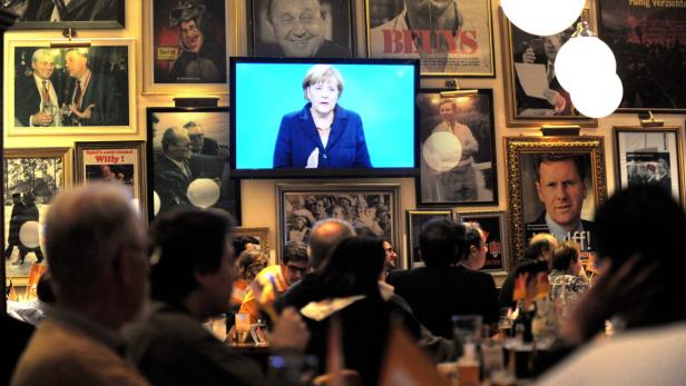 epa03847050 People watch the TV election debate between German Chancellor Angela Merkel and Social Democratic Party top candidate Peer Steinbrueck at a bar in Hannover, Germany, 01 September 2013. Germany will hold federal elections on 22 September. EPA/PETER STEFFEN