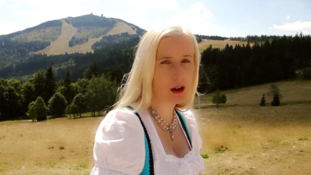 Eine Frau im Dirndl vor einer Berglandschaft.