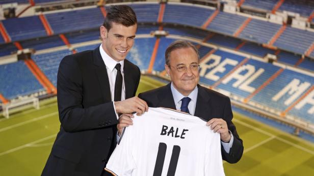 Gareth Bale (L) of Wales hold his new Real Madrid soccer club jersey accompanied by president Florentino Perezat the Santiago Bernabeu stadium in Madrid, September 2, 2013. The transfer window&#039;s longest-running saga finally ended on Sunday when Tottenham Hotspur forward Gareth Bale joined Real Madrid for a world transfer record fee of 100 million euros ($131.86 million). REUTERS/Paul Hanna (SPAIN - Tags: SPORT SOCCER BUSINESS)