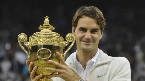 Roger Federer hält die Trophäe von Wimbledon in seinen Händen.