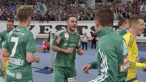 Ein Fußballspieler jubelt mit seinen Mannschaftskameraden vor einer Zuschauermenge.