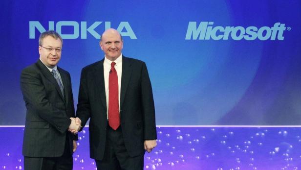 Nokia chief executive Stephen Elop (L) welcomes Microsoft chief executive Steve Ballmer with a handshake at a Nokia event in London in this February 11, 2011 file photograph. Microsoft Corp said on September 3, 2013 it would buy Nokia&#039;s mobile phone business for 5.44 billion euros ($7.2 billion), and the Finnish firm said its CEO Elop would join Microsoft when the transaction closed. REUTERS/Luke MacGregor/Files (BRITAIN - Tags: BUSINESS SCIENCE TECHNOLOGY TELECOMS)