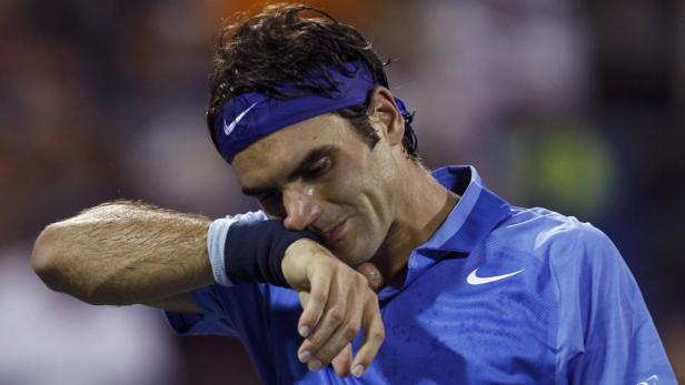 Roger Federer wischt sich während eines Tennisspiels den Schweiß von der Stirn.