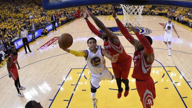 Stephen Curry von den Golden State Warriors beim Wurf auf den Korb, verteidigt von Spielern der Houston Rockets.