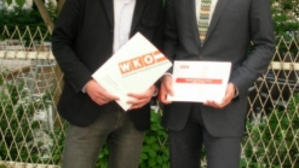 Zwei Männer im Anzug halten Dokumente der Wirtschaftskammer Österreich (WKÖ) in der Hand.