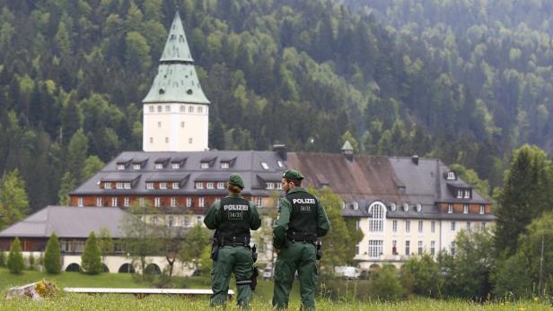 Zwei Polizisten stehen vor dem Schloss Elmau in den bayerischen Alpen.