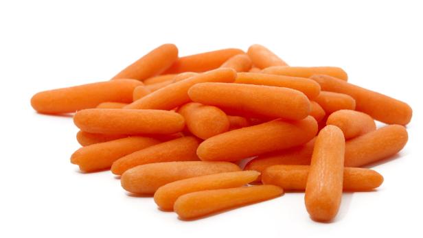 Ein Haufen geschälter Baby-Karotten auf einem weißen Hintergrund.