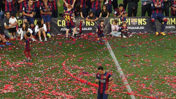 Spieler des FC Barcelona feiern einen Titelgewinn auf dem mit Konfetti bedeckten Rasen.