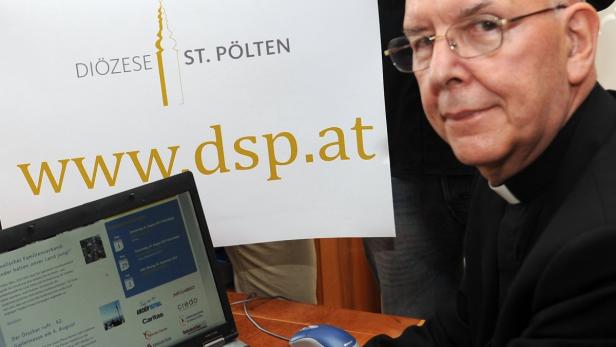 Ein Geistlicher der Diözese St. Pölten sitzt vor einem Laptop mit der Webseite www.dsp.at.
