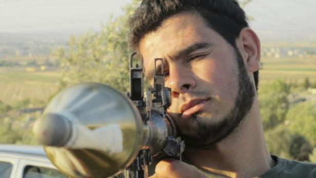 Ein Mann zielt mit einer Panzerfaust auf ein Ziel außerhalb des Bildes.