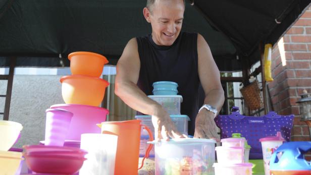 This Friday, Aug. 5, 2011 photo shows Kevin Farrell as he stacks some of his Tupperware products on a table while preparing for a Tupperware party in Bellflower, Calif. Tupperware, it seems, is enjoying a renaissance 65 years after it first hit the market with Wonder Bowls, Bell Tumblers and Ice-Tup molds for homemade frozen treats. (Foto:Garrett Cheen/AP/dapd)