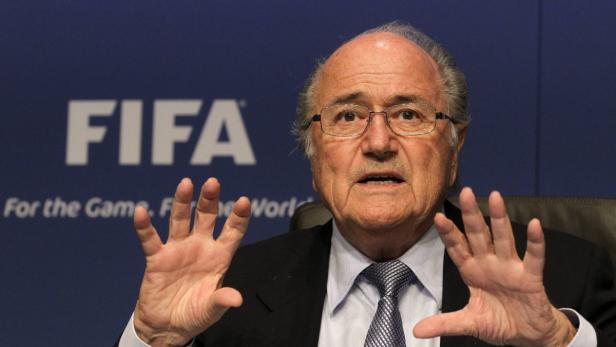 Sepp Blatter gestikuliert vor einem FIFA-Hintergrund.