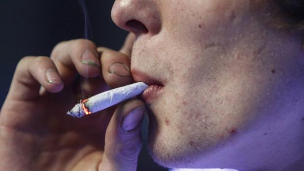 Russell Diercks smokes a half marijuana and tobacco joint inside of Frankie Sports Bar and Grill in Olympia, Washington in this file photo taken December 9, 2012. The Obama administration has decided not to sue Colorado and Washington over new laws that legalized recreational marijuana, allowing the two states to carry on their experiment as long as they follow new federal guidelines, a U.S. Justice Department official said on Thursday. REUTERS/Nick Adams/Files (UNITED STATES - Tags: HEALTH SOCIETY POLITICS CRIME LAW)