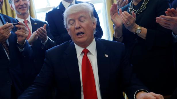 Liveris reacts as Trump gives him the pen he used