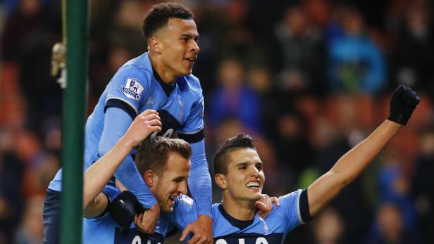 Drei Fußballspieler von Tottenham Hotspur feiern ein Tor.