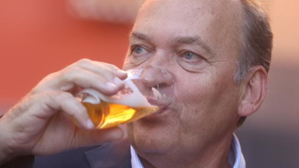 Ein Mann mittleren Alters trinkt ein Glas Bier.