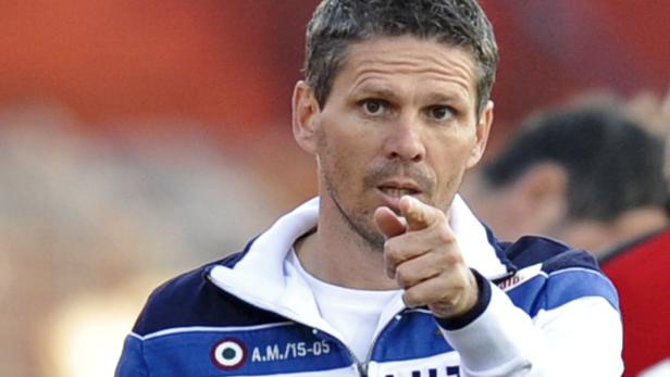 Ein Mann in einer blau-weißen Jacke zeigt mit dem Finger nach vorne.