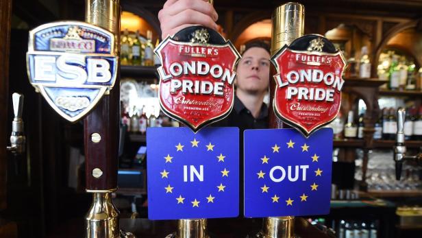 Zapfhähne in einer Bar mit „In“- und „Out“-Schildern vor dem Hintergrund des EU-Logos.