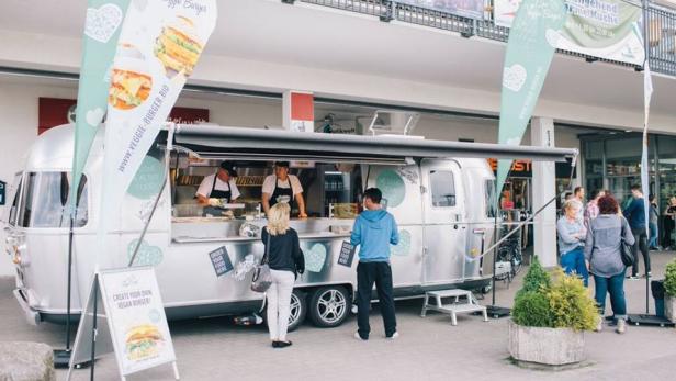 Ein silberner Imbisswagen verkauft Veggie-Burger.