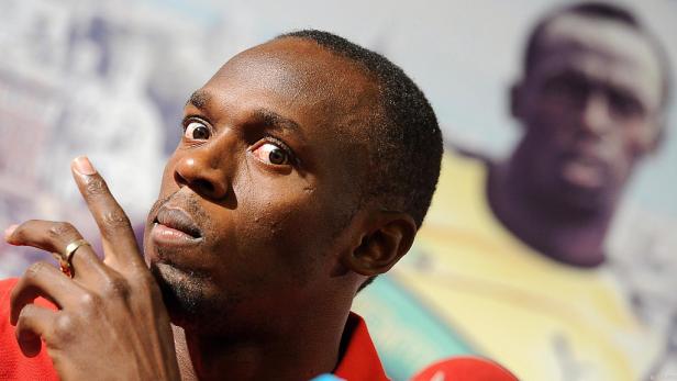 Usain Bolt gestikuliert während einer Pressekonferenz.