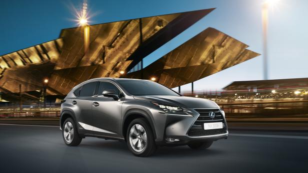 Ein grauer Lexus NX 300h fährt auf einer Straße entlang.