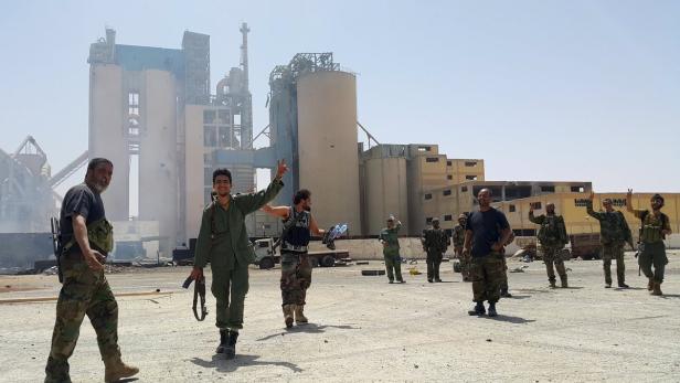 Members of forces loyal to Libya&#039;s eastern government are pictured near to the Libyan cement factory after the army took control of the factory following clashes with the Shura Council of Libyan Revolutionaries, an alliance of former anti-Gaddafi rebels who have joined forces with Islamist group Ansar al-Sharia, in Benghazi, Libya April 18, 2016. REUTERS/Stringer