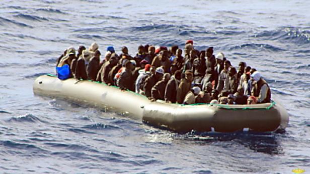 Ein überfülltes Schlauchboot treibt auf dem offenen Meer.