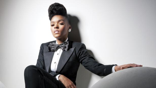 Janelle Monáe posiert in einem schwarzen Smoking mit Fliege.