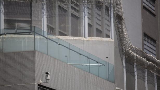 Ein Gebäude mit Überwachungskamera und Stacheldrahtzaun.