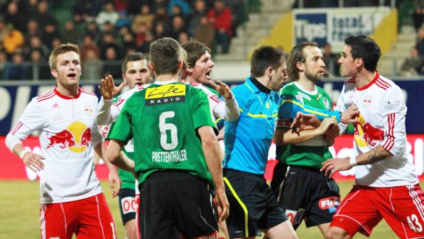 Fußballspieler während eines hitzigen Wortwechsels auf dem Spielfeld.